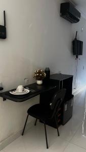 a black table with a chair and a plate on it at Studio 94 in Parauapebas +9 photos
