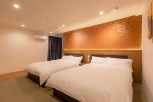 two beds in a hotel room with white sheets at Miro Hotel Dotonbori in Osaka +119 photos