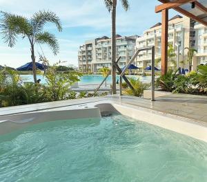 a swimming pool in a resort with palm trees and buildings at kristal lagoon view apartement in Cartagena de Indias
