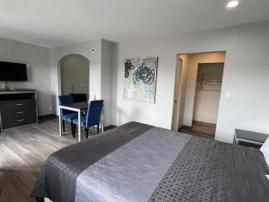 a hotel room with a bed and a table and a desk at Cloud 9 Inn - El Ciello Inn in Pico Rivera