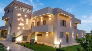 a large white building with lights on it at Orion Eco Suites in Karteros