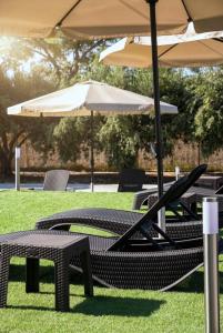 a group of chairs and tables with an umbrella at Orion Eco Suites in Karteros