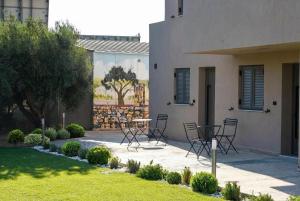 a patio with chairs and a table in front of a house at Orion Eco Suites in Karteros +51 photos