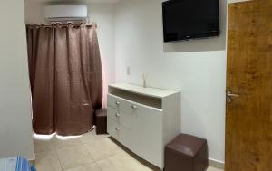 a bathroom with a dresser and a television on the wall at ALOJAMIENTO NORTE 1 in Santiago del Estero