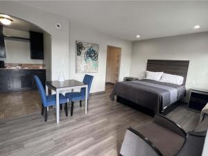 a hotel room with a bed and a table and chairs at Cloud 9 Inn - El Ciello Inn in Pico Rivera