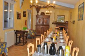 a dining room with a long table and chairs at Le Petit Labouret in Revest-du-Bion