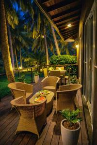 a patio with tables and chairs and palm trees at Coco forest camping in Kurunegala
