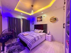a bedroom with a bed and a purple lighting at Engeemos Bookastay Apartments in Abeokuta