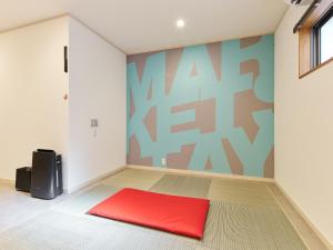 a room with a red bed in a room with a wall at マーケットステイ串本 MarketStay Kusimoto in Kushimoto +90 photos