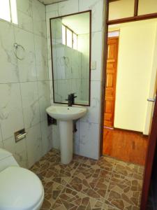 a bathroom with a sink and a toilet and a mirror at Tierra Espiritual - Andean Holistic Hotel in Puno