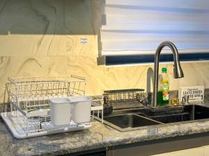 a kitchen sink with two dish drying racks next to it at Engeemos Bookastay Apartments in Abeokuta +32 photos
