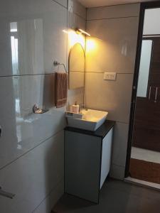a bathroom with a sink and a mirror at The Fortunara Crown Munnar in Munnar