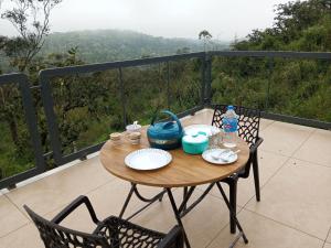 a table with plates and drinks on a balcony at The Fortunara Crown Munnar in Munnar