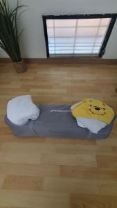 a bed with a pillow with a smiley face on it at Duplex cosy avec piscine à 2mn de la plage - Kaz Ti Plaj in Les Trois-Îlets
