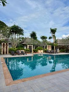 a swimming pool with chairs and a house at Bhumlapa Garden Resort in Bophut