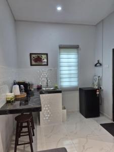 a kitchen with a counter and a sink in a room at NAR Kampung Studio in Bayan Lepas
