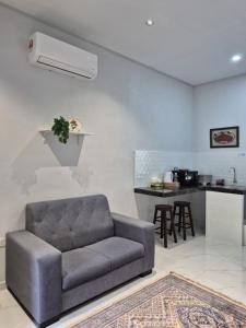 a living room with a couch and a kitchen at NAR Kampung Studio in Bayan Lepas