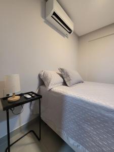a bedroom with a bed and a table with a lamp at Way Bossa by Solis in João Pessoa