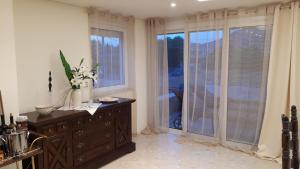 a kitchen with a dresser with flowers on it at Lagonisi Beach Villa in Lagonissi +29 photos