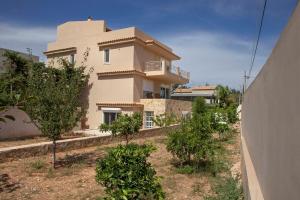 a large white house with trees in front of it at Lagonisi Beach Villa in Lagonissi