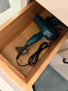 a blow dryer in a wooden drawer in a cabinet at Eastside Costa Mesa Residence in Costa Mesa