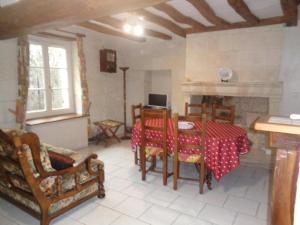 a living room with a table and chairs and a fireplace at Maison tourangelle restaurée, 3 chambres, jardin clos, village viticole, proche loisirs et équipements bébé - FR-1-381-236 in Restigné