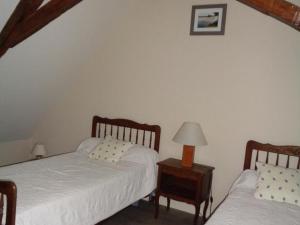 a bedroom with two beds and a table with a lamp at Maison tourangelle restaurée, 3 chambres, jardin clos, village viticole, proche loisirs et équipements bébé - FR-1-381-236 in Restigné