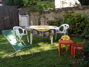 a table and chairs in a yard with a table and chairs at Maison tourangelle restaurée, 3 chambres, jardin clos, village viticole, proche loisirs et équipements bébé - FR-1-381-236 in Restigné