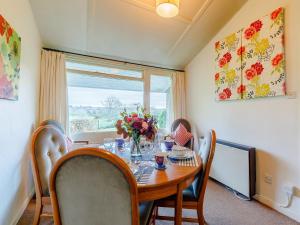 a dining room with a table with chairs and a window at Hall Farm Bungalow in Shirley