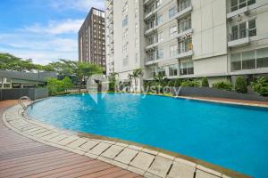 a large blue swimming pool in front of some buildings at Elion by Kozystay - BSD in Samporo