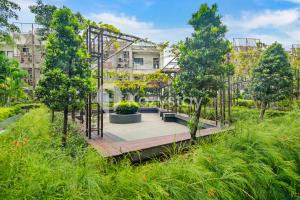 a garden with trees and a wooden bridge at Elion by Kozystay - BSD in Samporo