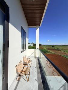 a balcony of a house with two chairs on it at Lúa Vàng homestay in Pleiku Airport