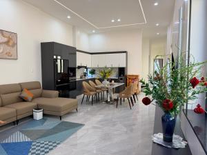 a living room with a couch and a table and chairs at Lúa Vàng homestay in Pleiku Airport