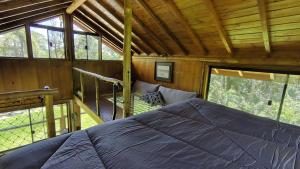 a bedroom with a bed in a cabin with windows at Floresta Mandaçaia in São Roque +14 photos