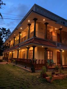 a large white building with a porch and balcony at Surendram Villa in Varkala
