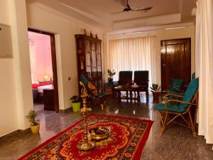 a living room with a red rug on the floor at Surendram Villa in Varkala