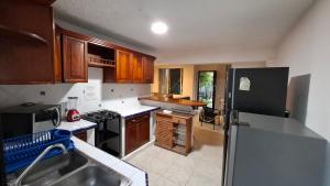 a kitchen with wooden cabinets and a black refrigerator at Residencia COCO 28 con Piscina Downtown Cancun in Cancún