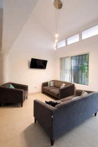 a living room with two couches and a flat screen tv at Residencia COCO 28 con Piscina Downtown Cancun in Cancún