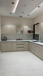 an empty kitchen with white cabinets and a sink at O2P Al Salam in Medina