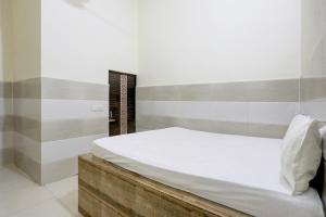 a bedroom with a bed with a wooden headboard at Hotel O The Starlight in Ghaziabad