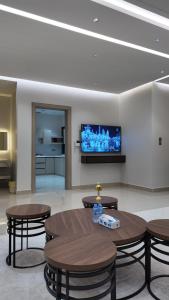 a room with tables and a flat screen tv at O2P Al Salam in Medina