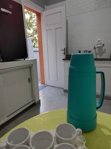 a green mug sitting on top of a table with cups at Loft Cruzeiro in Belo Horizonte