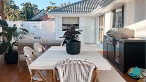 a table and chairs on a patio with a kitchen at Summerland Escape in Summerland Point