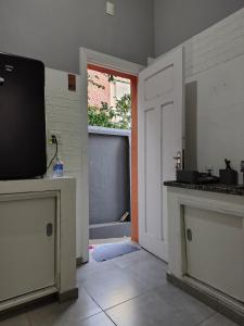 a kitchen with a tv on a counter and a door at Loft Cruzeiro in Belo Horizonte