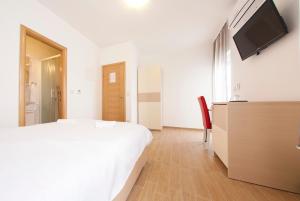 a bedroom with a bed and a flat screen tv at Guesthouse Villa Klara in Baška Voda