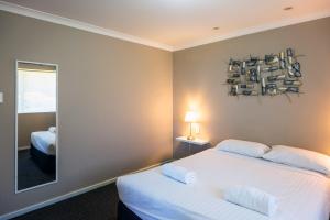a bedroom with two beds and a mirror at Grandis 35 in Albany