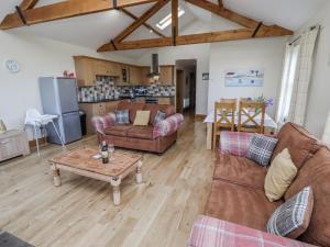 a living room with two couches and a table at Home Stead Cottage in Embleton