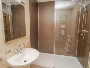 a bathroom with a sink and a shower at Home Stead Cottage in Embleton +32 photos