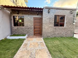 a brick house with a door and a grass yard at Casa Zapata in Chano