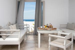 a white dining room with a table and chairs at Kanale's Rooms & Suites in Naousa